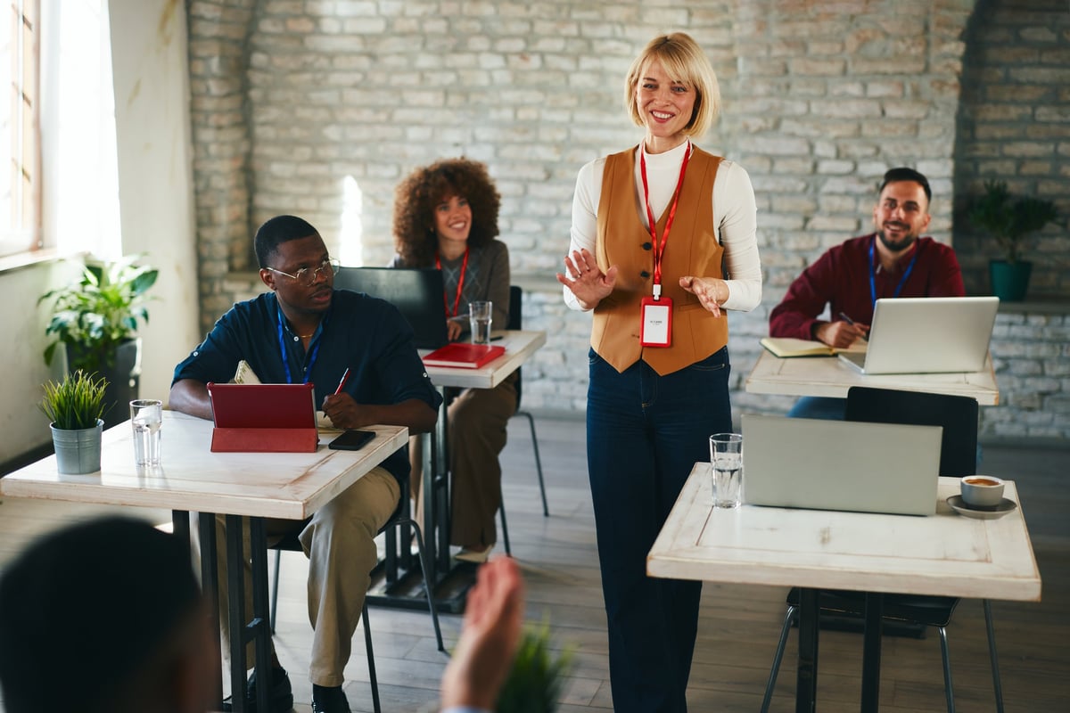 An executive presenter leading a leadership session with a diverse team of professionals