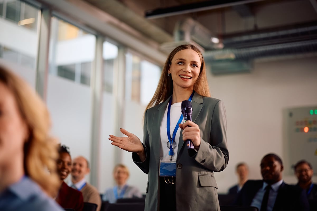 A seminar attendee asking a question during a business conference session